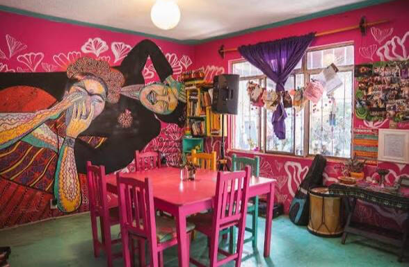 Comedor del hostal Histórika con sillas rosas